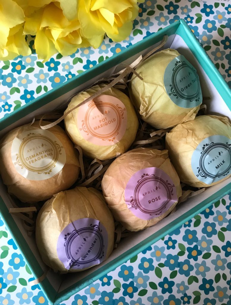 Aprilis Bath Bombs box open to show 6 wrapped bath bombs in different scents, neversaydiebeauty.com