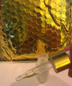 glass dropper filled with Shine Brightening Oil, neversaydiebeauty.com