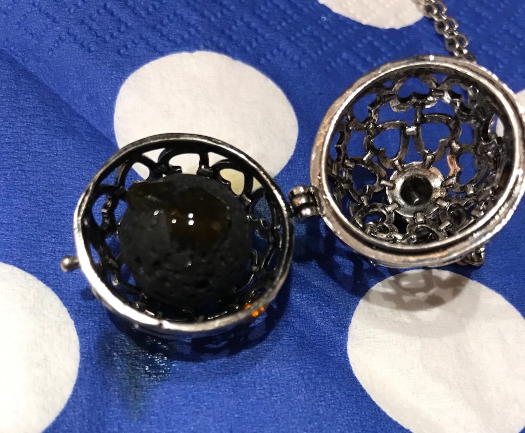 essential oil dropped onto a lava ball inside an aromatherapy necklace, neversaydiebeauty.com