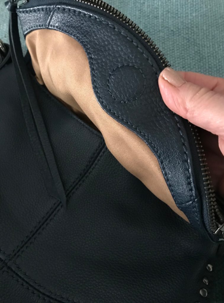 magnet closure inside The Sak navy blue crossbody purse, neversaydiebeauty.com