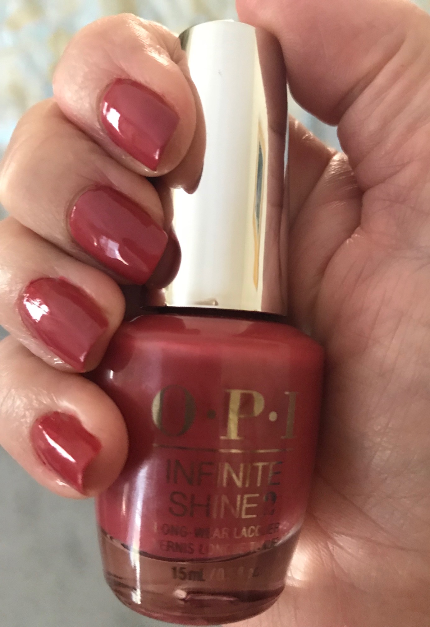 my nails wearing OPI Infinite Shine 2 Grand Canyon Sunset holding the bottle, neversaydiebeauty.com