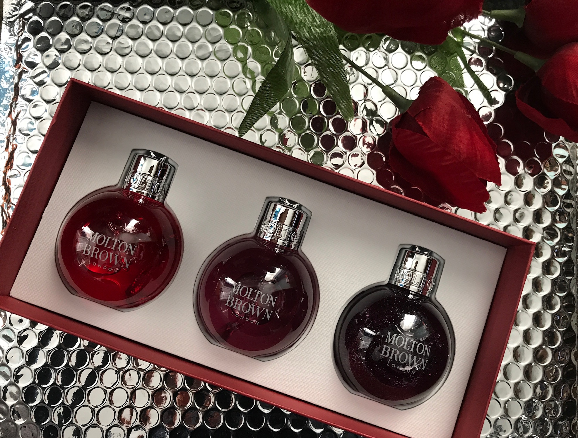 inside the Molton Brown Festive Bauble Set with 3 2.5 fl. oz. "ornaments" with shower gels: Pink Pepper, Frankincense & Allspice and Muddled Plum, neversaydiebeauty.com