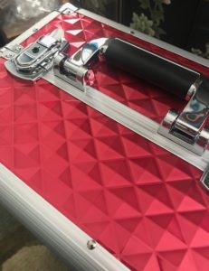 the top handle and clasps of the red Yaheetech train case makeup trolley, neversaydiebeauty.com