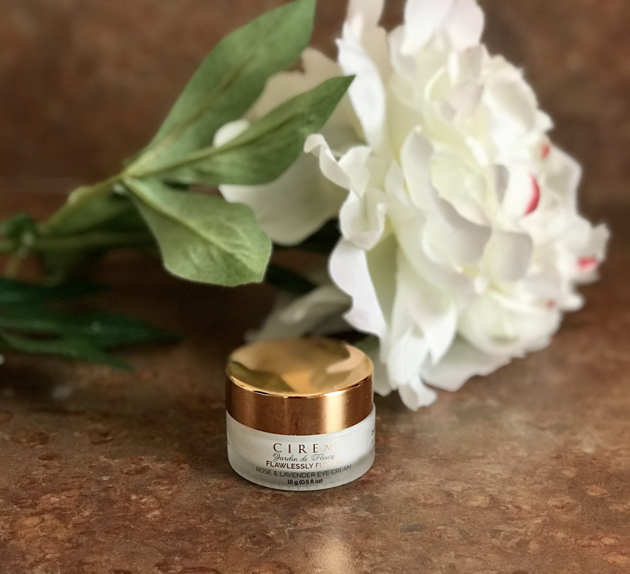 frosted plastic jar with rose gold top of CIREM Cosmetics Jardins des Fleur Rose and Lavender Eye Cream