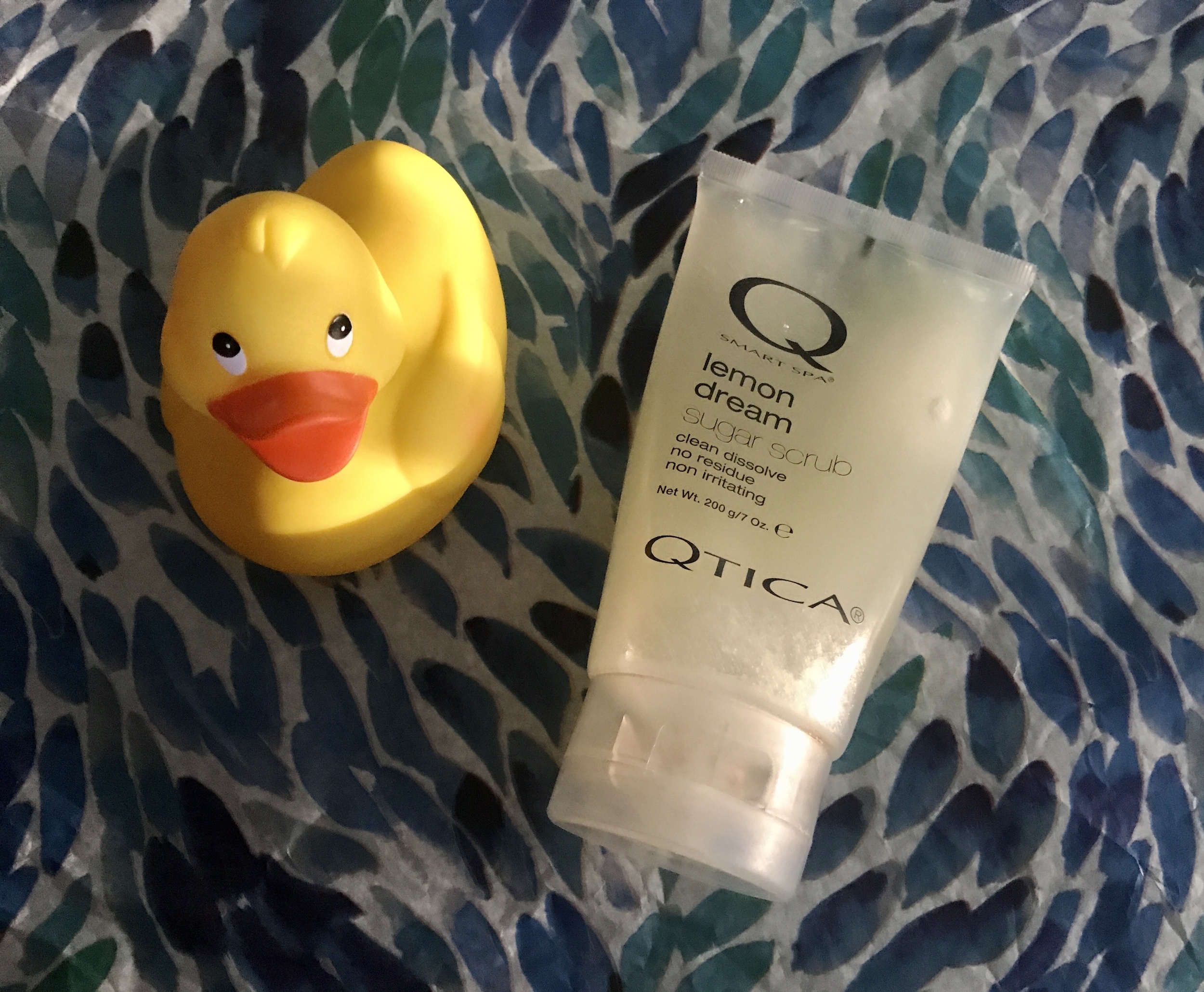 tube of Qtica Smart Spa Lemon Dream Sugar Scrub along with a yellow rubber duck